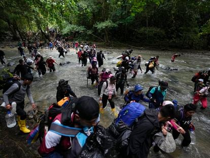 Migrants cross a river in the Darién jungle to reach Panama, on October 15, 2022.