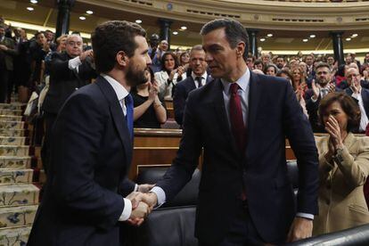 Popular Party leader Pablo Casado (l) congratulates Pedro Sánchez after the latter's confirmation in office by 167 votes to 165. The main opposition conservatives have accused the Socialist leader of betraying Spain after the latter sought the support by way of abstention from Catalan separatist lawmakers.