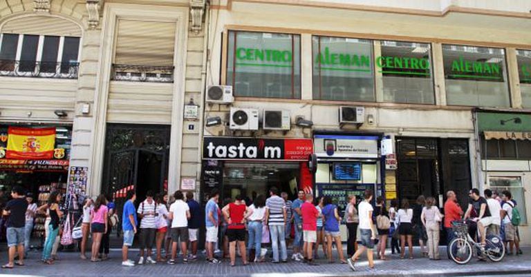 Hundreds of people wait in line in Valencia to sign up for German classes.