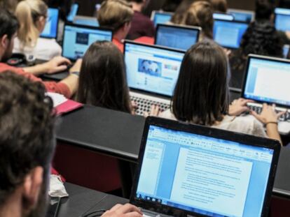 Students with personal computers attend class.