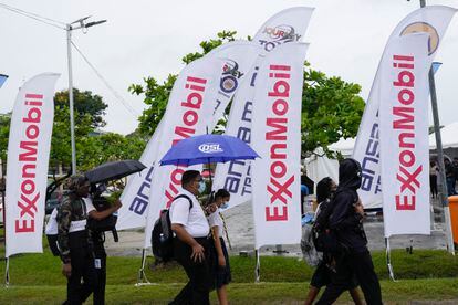 High school students walk past ExxonMobil flags as they arrive to a job fair at the University of Guyana in Georgetown, Guyana, April 21, 2023.