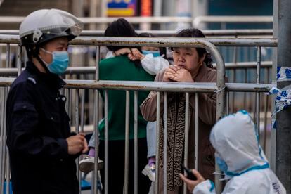 A woman at the entrance of a residential building under quarantine in Shanghai.