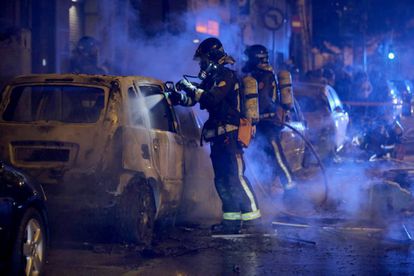 Firefighters put out fires set by protesters in Barcelona.