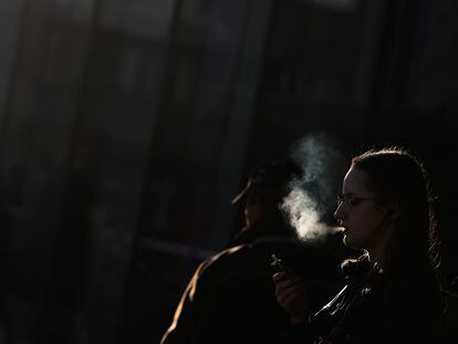 A woman smokes on a street in Krakow in March.