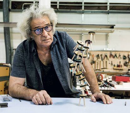 Javier Bermejo poses in front of the game The Stools, a construction game where players balance each piece on top of each other.