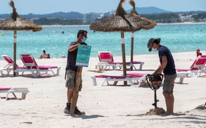 Workers putting up an information sign at the beach in Alcúdia, Mallorca on May 12.