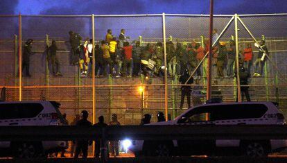 A group of migrants attempting to jump the border fence in Melilla in October 2014.