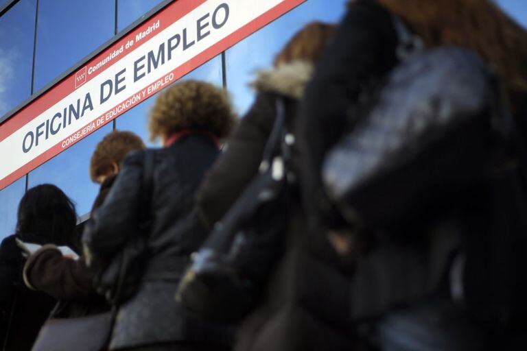 Women stand in line outside an unemployment office.