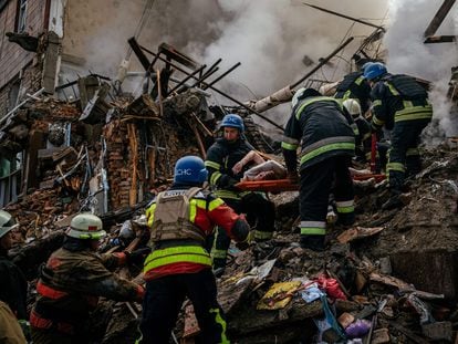 Ukrainian firefighters carry the body of a civilian killed after a strike in Zaporizhia on Thursday.