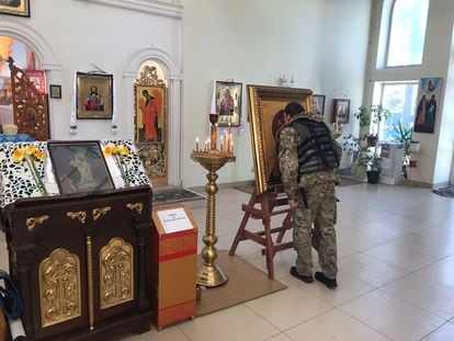 A soldier kisses an image in the church of the Virgin of Pochaev, in Bucha.
