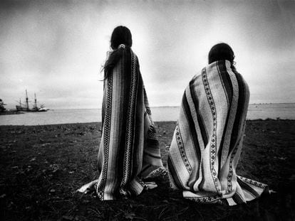 Two women of the Wampanoag Nipmucs look across to the Mayflower replica anchored near Plymouth Rock, on November 26, 1991.