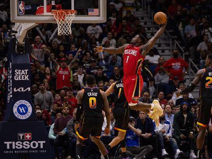 New Orleans Pelicans forward Zion Williamson (1) dunks the ball against Phoenix Suns guard Devin Booker (1) and forward Torrey Craig (0) during the second half at Smoothie King Center.