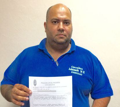 Juan Carlos Puyoles holds up the police complaint.