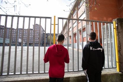 Two students look at a closed school in the Basque city of Vitoria during the coronavirus lockdown.