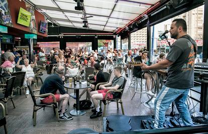 UK tourists listen to live music at a bar in Benidorm.