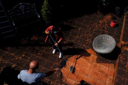 Residents clean up the ash from the volcano in the yard of their house on La Palma, Spain on Thursday. 