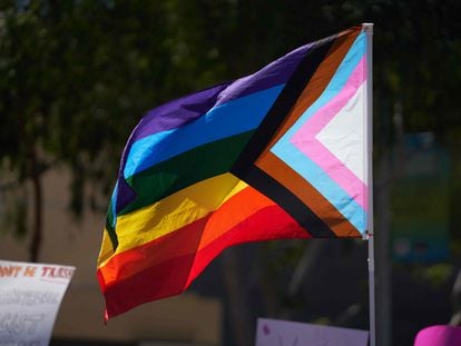 A Progress Pride Flag is held above a crowd of LGBTQ+ activists on April 9, 2023.