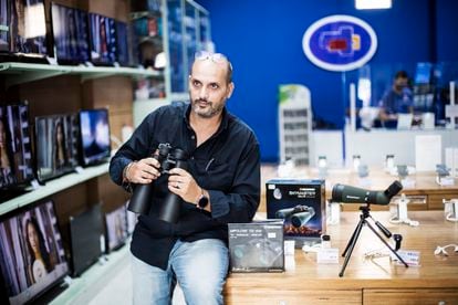 Antonio González in his technology store, with some of the binoculars he has been selling recently.