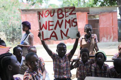 A child holds up a sign reading: "We need the nurse" during a protest to demand the release of American nurse Alix Dorsainvil and her daughter, who were kidnapped by armed men, in Port-au-Prince, Haiti.