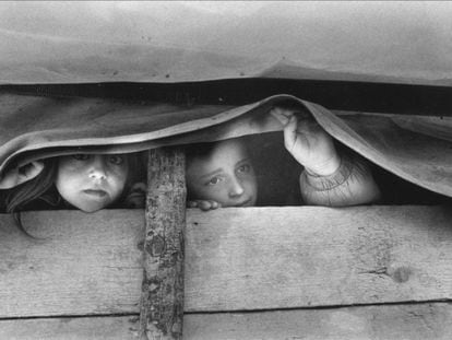 Two Kosovar Albanian refugee girls look out from inside a covered wagon in Morina, Albania, April 1999.
