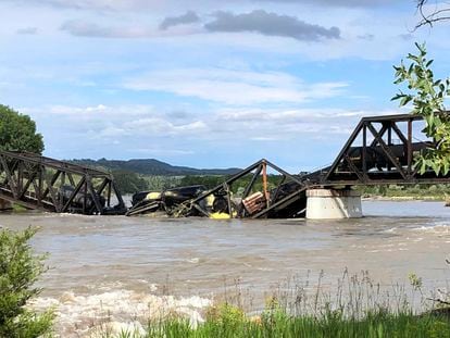 Several train cars are immersed in the Yellowstone River after a bridge collapse near Columbus, Mont., on Saturday, June 24, 2023.