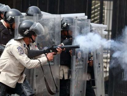 Anti-riot police battle with protestors in Caracas on Tuesday.