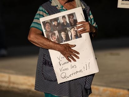 A woman holds up a sign with pictures of the seven kidnapped teens in Zacatecas.