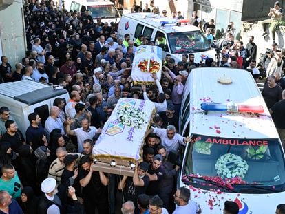 People carry the coffins during the funeral procession for the three children and their grandmother killed in an Israeli airstrike in southern Lebanon