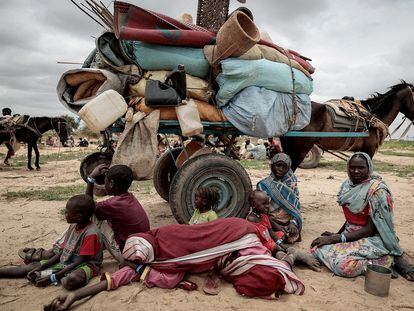 A Sudanese family, with their belongings, waits at the Chad border after fleeing Darfur last July.