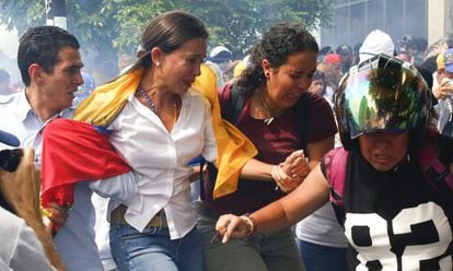 María Corina Machado flees the tear gas fired at Tuesday's rally.