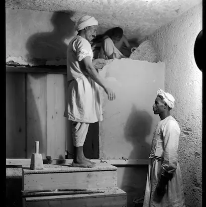 Three Egyptian workers dismantle the wall between the antechamber and the burial chamber in Tutankhamun’s tomb. 