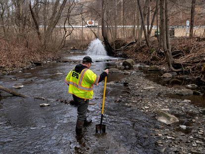 Ron Fodo, Ohio EPA Emergency Response, looks for signs of fish and also agitates the water in Leslie Run creek to check for chemicals that have settled at the bottom following a train derailment that is causing environmental concerns on February 20, 2023 in East Palestine, Ohio.