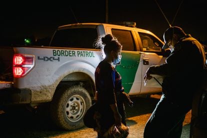 A border patrol officer processes a migrant woman after crossing the Rio Grande into Texas.