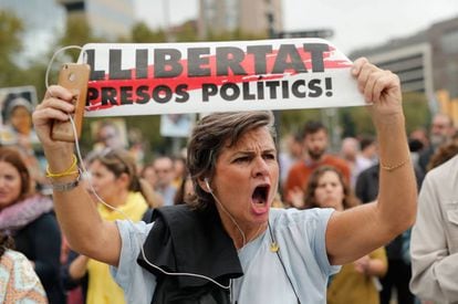 A woman holds a a banner reading “Freedom for political prisoners!”