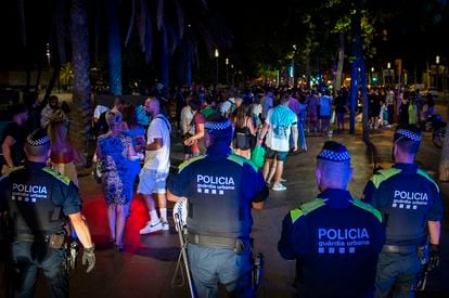 Police break up an outdoor drinking session in Barcelona being held in violation of the curfew last summer.