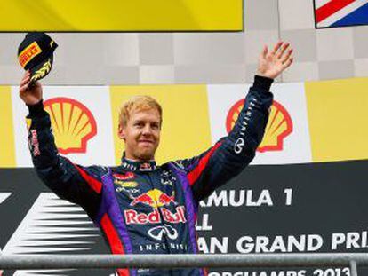First-placed German driver Sebastian Vettel of Red Bull Racing celebrates on the podium together with second-placed Fernando Alonso (l) and Lewis Hamilton of Mercedes.