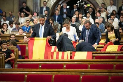 Deputies inside the Catalan parliament exhibiting Spanish and Catalan flags.