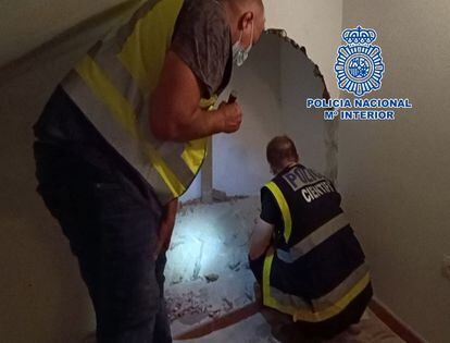 Members of the National Police locating the body behind a wall in the apartment. 