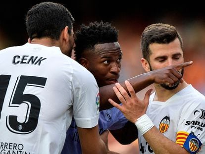 Real Madrid's Vinícius Júnior gestures towards a fan as Valencia's Jose Gaya and Cenk Ozkacar attempt to restrain him on May 21, 2023.