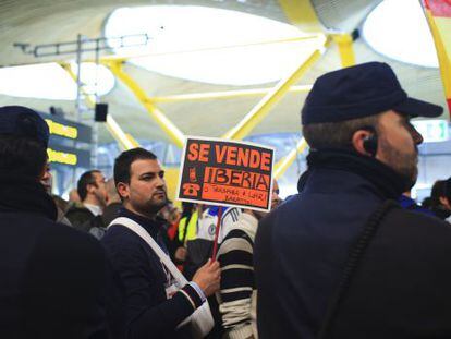 A protestor carries a banner reading &quot;Iberia for sale&quot; during a strike by Iberia airline employees at Madrid airport in Madrid on Monday.