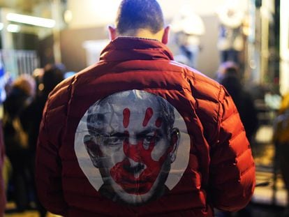 A protester with a jacket bearing Netanyahu's face and a blood-stained handprint  inTel Aviv, January 3.