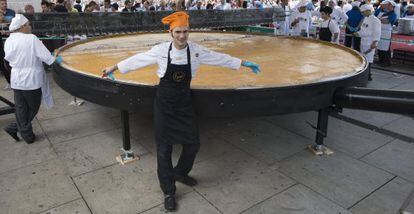 Chef Senén González poses in front of the pan used to make a giant Spanish omelet in Vitoria.
