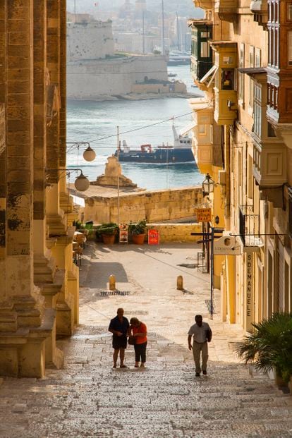 Walkers through one of the streets of Valletta, in Malta.