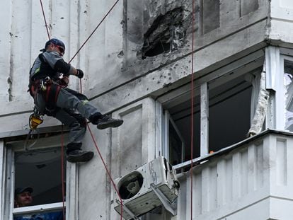 A specialist inspects the damaged facade of a multistory apartment building after a reported drone attack in Moscow on May 30, 2023.