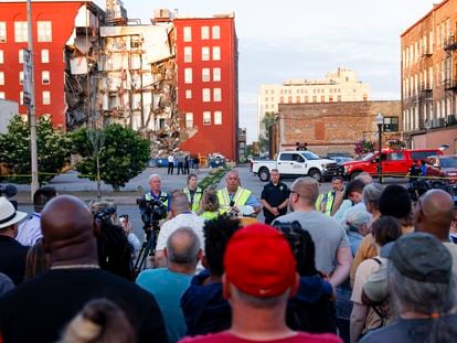 Officials update to media, residents and onlookers after a partial building collapse on the 300 block of Main Street, on May 28, 2023, in Davenport, Iowa.