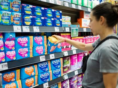 A woman buys sanitary towels in a supermarket.