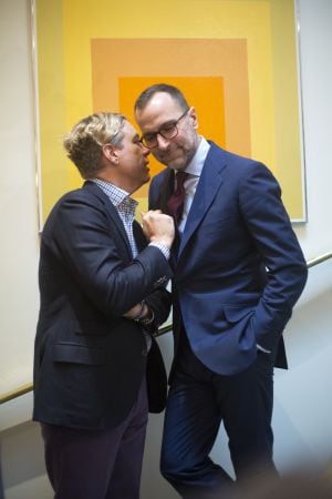 US Ambassador James Costos (right) and his partner, interior decorator Michael Smith, talk in front of a work by Josef Albers.