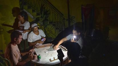 A group of Cubans play dominoes in the middle of a blackout in Havana.