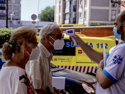 A healthcare worker takes a man's temperature in Villaverde, Madrid.