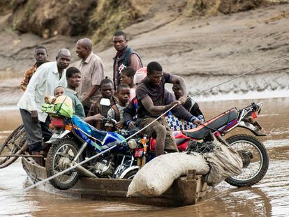 Men transport their salvaged belongings in Chiradzulu, southern Malawi, on March 17, 2023.